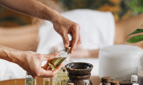 Ayurveda aromatherapy massage, female hand pouring aromatic oil in an essential oil diffuser